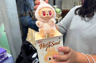 Dubai, BAE - 18 Mayıs 2025: Pop Mart Labubu 'nun yakın planında müşteriler tarafından tutulan kırmızı gözlü bir koltuğu var. TikTok ve bobinlerde popüler olan The Monsters serisinden moda oyuncaklar.