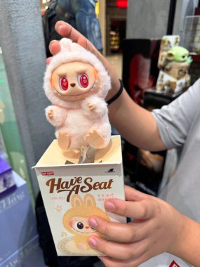 Dubai, BAE - 18 Mayıs 2025: Pop Mart Labubu 'nun yakın planında müşteriler tarafından tutulan kırmızı gözlü bir koltuğu var. TikTok ve bobinlerde popüler olan The Monsters serisinden moda oyuncaklar.