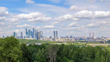 Moskova 'nın Vorobyovy Gory' den ufuk çizgisi Moskova Nehri, yeşil ağaçlar ve mavi gökyüzündeki bulutlar. Moskova ufuk çizgisi ufka hükmediyor, çarpıcı bir sahne yaratıyor.