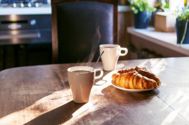 Bir fincan sıcak kahve ve taze kruvasanla kahvaltı. Yüksek kalite fotoğraf