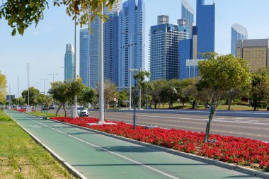 Abu Dabi, BAE 'nin gökdelenlerine bakan bisiklet yolu. Abu Dabi Corniche Parkı. Yüksek kalite fotoğraf