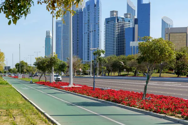 Abu Dabi, BAE 'nin gökdelenlerine bakan bisiklet yolu. Abu Dabi Corniche Parkı. Yüksek kalite fotoğraf