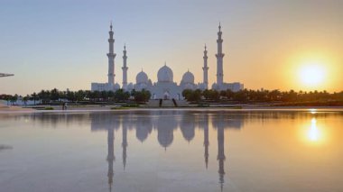 Gün batımında Abu Dabi 'deki Şeyh Zayed Büyük Camii. Şaşırtıcı İslami mimari, suyun barışçıl yansıması, maneviyat, kültür ve BAE zarafetinin sembolü.