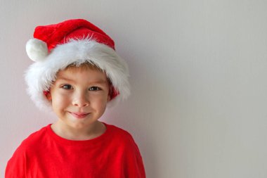 Şenlikli tatil kıyafetleri içindeki neşeli çocuk arka planda sade bir şekilde fotokopi çekiyor. Yüksek kalite fotoğraf