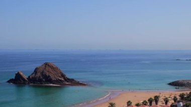Fujairah, BAE 'deki Snoopy Adası. Kumsalın turkuaz suları, kayalık bir ada ve yakınlardaki bir tatil köyü manzarası. Yüksek kalite fotoğraf
