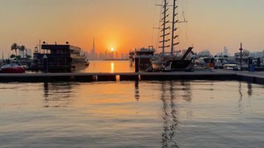 Dubai, BAE. 26 Eylül 2025. Dubai semalarında gün batımı Dubai Creek limanı manzarası, yatlar ve modern şehir manzarası