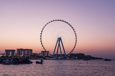 Dubai, BAE. 3 Ekim 2025. Bluewaters Adası ve Dubai Marina Ferris Tekerleği 'nin gün batımı manzarası, sakin şehir manzarası, seyahat sahnesi