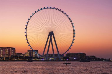 Bluewaters Adası ve Dubai Marina Dönme dolabı üzerinde akşam güneşi manzarası, tatil, seyahat, manzaralı gökyüzü.