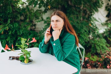 Üzgün genç bir kadın telefonda hayal kırıklığına uğramış konuşuyor. Kötü haberleri duyuyor, kötü düşünceli bir kız konuşuyor. Hoş olmayan akıllı telefon konuşmaları yapıyor..