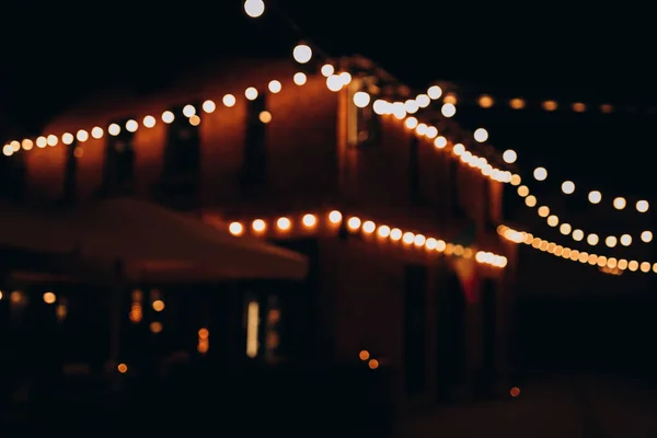 stock image Decorative outdoor string lights at night time, Defocused Background, night city life backdrop, party time with bokeh balls