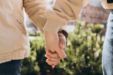 Bulanık arka planda el ele tutuşan iki kişi. Yardım eli uzatıyorum..