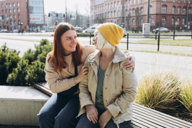 Mutlu arkadaşlar birbirini kollar. Mutlu olgun bir anne ve yetişkin bir kız çocuğu. Gülüyorlar, sarılıyorlar, şefkatli genç bir kadın. Birlikte vakit geçiriyorlar.