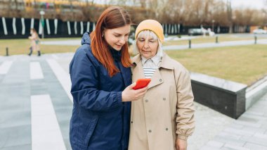 Kadınlar açık havada ne ile ilgilendiklerini öğrenmek için akıllı telefon kullanırlar. İnternet ve ağ oluşturma kavramı hakkında bilgi aranıyor