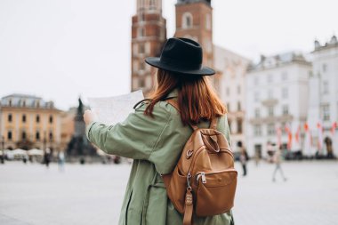 Çekici genç bayan turist yeni şehri keşfediyor. Kızıl saçlı kız Krakow 'da elinde kağıt bir haritayla dolaşıyor. İlkbaharda Avrupa 'yı geziyorum. Kentsel yaşam tarzı konsepti