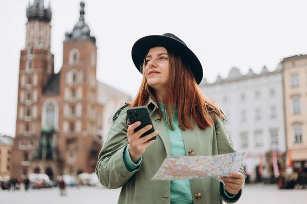크라코프의 스퀘어에서 모자를 아름다운 핸드폰 지도를 있습니다 방식의 네트워크를 점검하고 — 스톡 사진