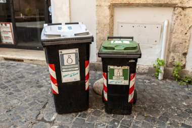 Roma, İtalya - 07 Nisan 2022, kentsel bir caddenin kaldırımı boyunca bazı umumi çöp kovaları.