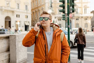 Şehir caddesinden akıllı telefonlu mutlu genç bir adam arıyor. Teknoloji, iletişim ve insan kavramı