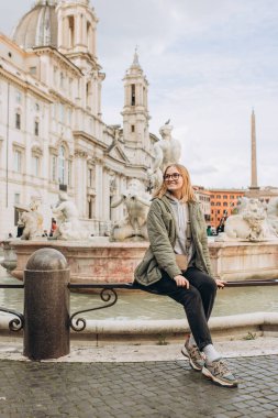 Roma, İtalya 'daki ünlü Piazza Navona' nın önünde mutlu bir sarışın kadın turist duruyor. Seyahat eden ünlü simgeler kavramı.