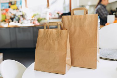 Güneşli bir günde yemek torbaları masanın üstünde. Saat başı hava koşullarında müşteriye teslim edilecek. Fast food ekolojik paketleme ve büyük bir kahvaltı.