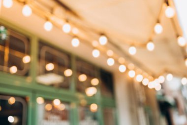 Blurred background of outdoor restaurant with abstract bokeh light.