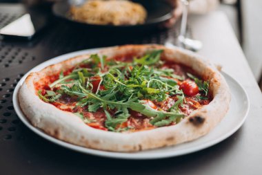 Domates, roka ve peynirli taze pizza.