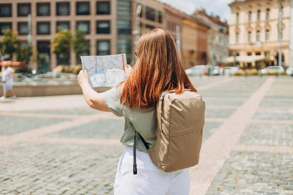 带着地图的快乐的旅游女孩在欧洲旅行 通过探索有趣的旅行地点来实现度假的理念 红头发女性搜寻地点 — 图库照片