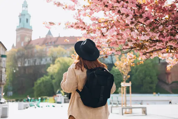 Çekici genç bayan turist yeni şehri keşfediyor. 30 'lu yaşlardaki kızıl saçlı kız kasabanın arka planında dinleniyor. İlkbaharda Avrupa 'yı gezmek