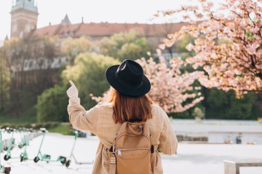 Çekici genç bayan turist yeni şehri keşfediyor. 30 'lu yaşlardaki kızıl saçlı kız kasabanın arka planında dinleniyor. İlkbaharda Avrupa 'yı gezmek