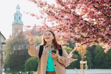 Çekici genç bayan turist yeni şehri keşfediyor. Wawel Kalesi, Cracow, Polonya yakınlarında oturan 30 'lu yaşlardaki kızıl saçlı kız. İlkbaharda Avrupa 'yı geziyorum. Yüksek kalite fotoğraf