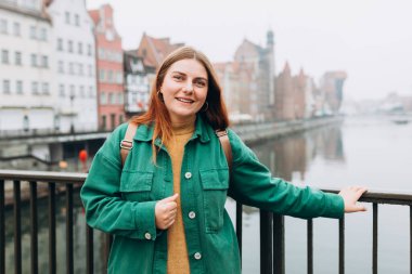 Çekici genç bayan turist yeni şehri keşfediyor. Gdansk eski kasaba ve Zuraw Crane Motlawa nehrinin yanında güzel bir kadın duruyor.