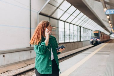 Genç mülteci kızıl saçlı kadın istasyonda ağlayıp tren istasyonunda bekliyor. Kayıp ya da geç, mutsuz kız akıllı telefondan konuşuyor..
