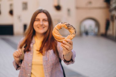 Çekici genç bayan turist, Krakow 'daki pazar meydanında geleneksel Polonya yemeği tutuyor. İlkbaharda Avrupa 'yı geziyorum. Seçici odak.