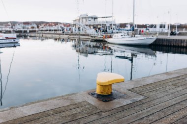 Rıhtımdaki gemileri demirlemek için demir çubuk. Deniz rıhtımının manzarası. Yat tekneleri ve ahşap iskelesi olan Marina.