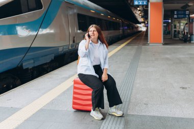 Telefonda hayal kırıklığına uğramış üzgün bir kadın kötü haberler duyuyor, üzgün düşünceli bir kız hoş olmayan bir telefon konuşması yapıyor ve tren istasyonunda duruyor. Trenle seyahat et. Olumsuz duygu