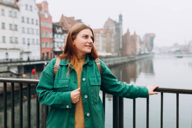 Çekici genç bayan turist yeni şehri keşfediyor. Gdansk eski kasaba ve Zuraw Crane Motlawa nehrinin yanında güzel bir kadın duruyor.