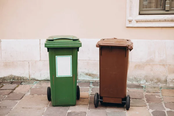 Waste separation, two different color trash can bins standing in front of the house in public along street. Help to reduce waste, Help global warming. Garbage bins for waste segregation.