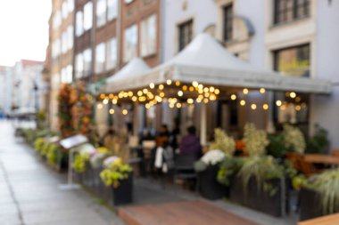 Terasın iç tarafının çelenk ışıklarıyla bulanık görüntüsü.