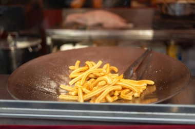 Geleneksel İspanyol tatlısı, şekerli. Churros satışı. Tipik İspanyol çörekleri satmak için adil bir tezgah.