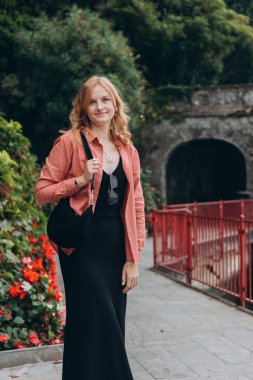 Mutlu sarışın 30 'lu yaşlardaki kadın yaz tatilinin tadını çıkarıyor. Tatil ve seyahat kavramı. Varenna, İtalya. Como Gölü