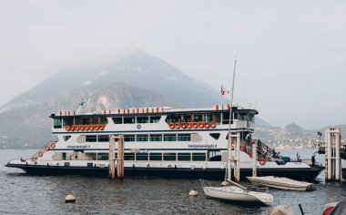 COMO, İtalya. 12 Ekim 2023. Büyük feribot ulaşımı. Arabalar ve harika limanlarda insanlar var. Alplerdeki küçük sahil tatil köyü. Manzaralı manzara. Deniz aracı.