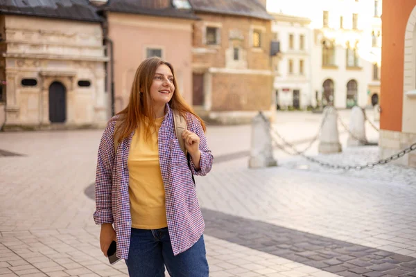 Sırt çantalı çekici genç bayan turist yeni bir şehri keşfediyor. Eski şehir caddesinde yürüyen 30 'lu yaşlarda bir kadın. Yazın Avrupa seyahati, şehir geçmişi