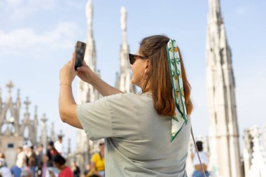 30 'ların güzel kadını Milan Katedrali Duomo di Milano' nun çatısında selfie çekiyor. Yazın Avrupa 'yı geziyorum. Çekici kadın şehri keşfediyor.