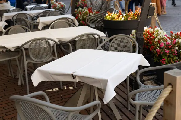 Dining outdoors. Outdoor street cafe tables ready for service. Empty cafe terrace with table and chair
