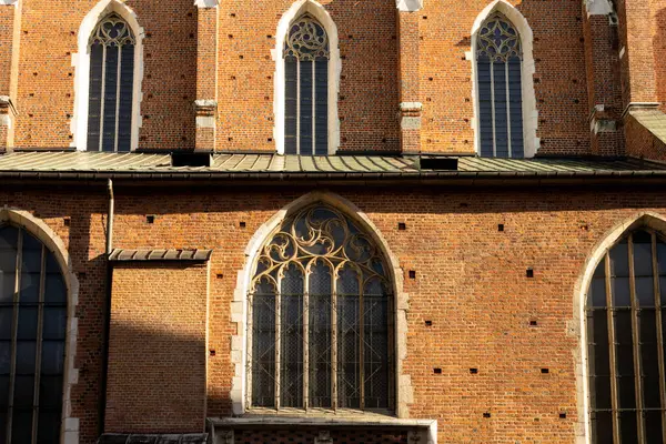 Large decorative church windows with stained glass. Fragment of the wall and stained glass windows of the Catholic Church in the old town of Krakow