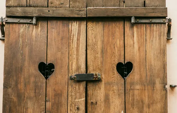 Old wooden Window shutters with hearts. Sad Valentine, lost love, love end, relations crisis, relationship problem metaphor concept.