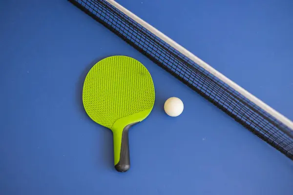 Blue ping pong table. Ping pong racket and ball. The concept of sport and healthy lifestyle.