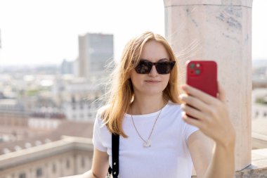 30 'ların güzel kadını Milan Katedrali Duomo di Milano' nun çatısında selfie çekiyor. Yazın Avrupa 'yı geziyorum. Çekici kadın şehri keşfediyor, turist akıllı telefondan fotoğraf ya da video çekiyor
