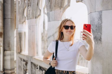30 'ların güzel kadını Milan Katedrali Duomo di Milano' nun çatısında selfie çekiyor. Yazın Avrupa 'yı geziyorum. Çekici kadın şehri keşfediyor, turist akıllı telefondan fotoğraf ya da video çekiyor