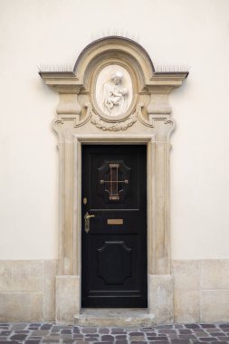 Küçük pencereli ahşap bir kapı.