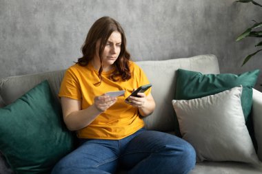 Mutsuz genç kızıl saçlı kadın iflasın eşiğinde ya da kredi kartıyla internetten borç alışverişi yapıyor. Mutlu 30 'lu yaşlardaki kadınlar kanepede oturur ve evlerinde vakit geçirirler..